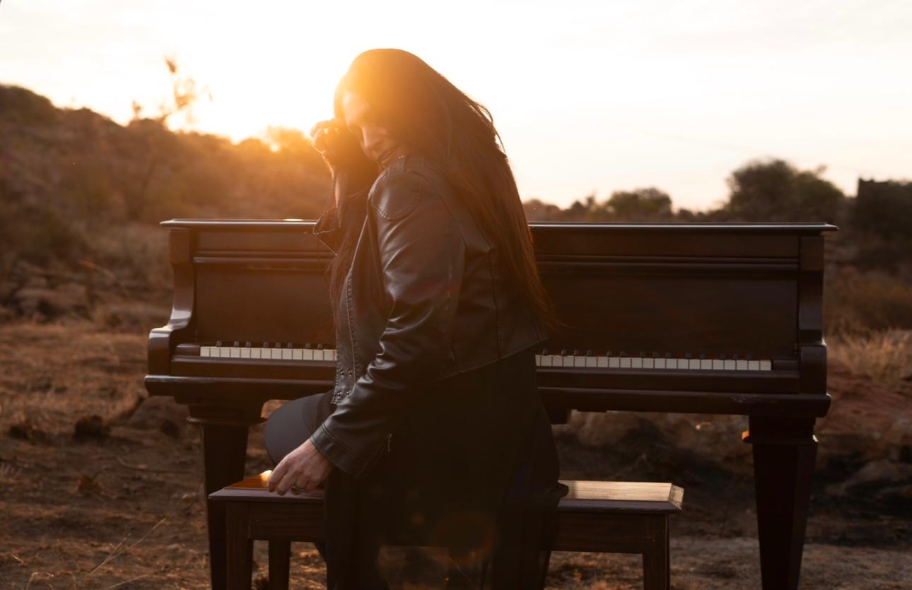 Riana Nel beside the grand piano at sunset