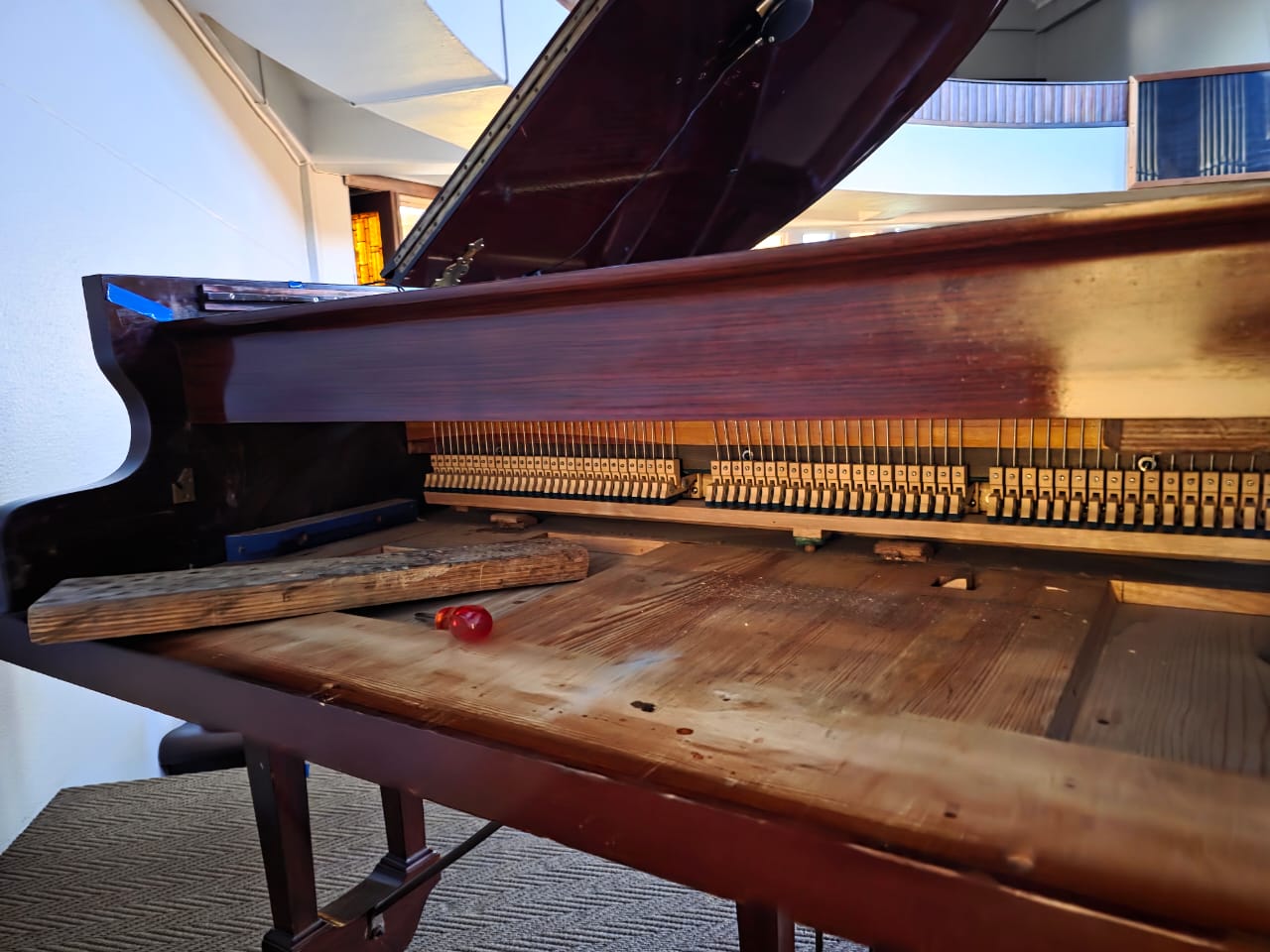 The open interior and action of a grand piano during restoration