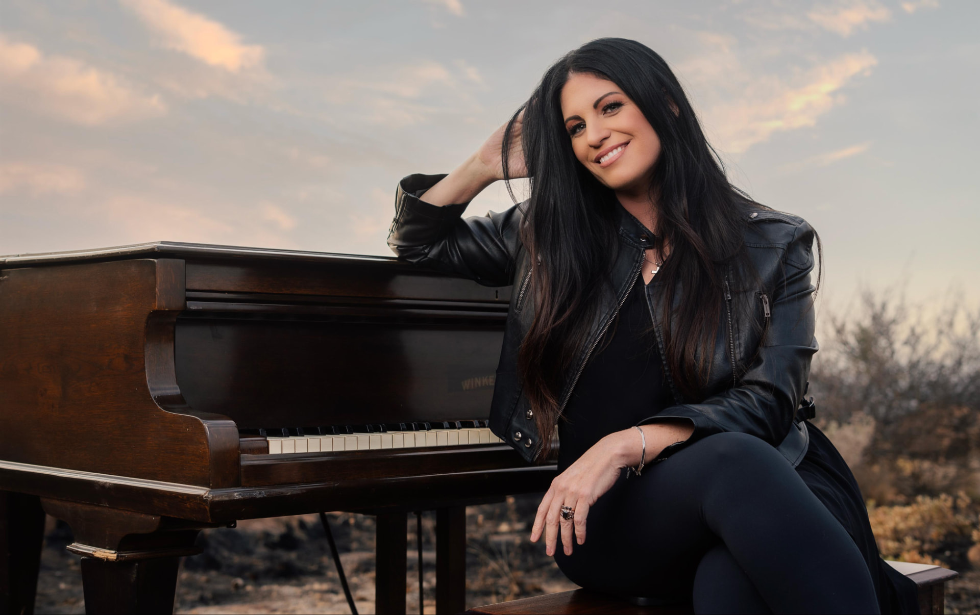 Riana Nel seated alongside the grand piano on the mountain