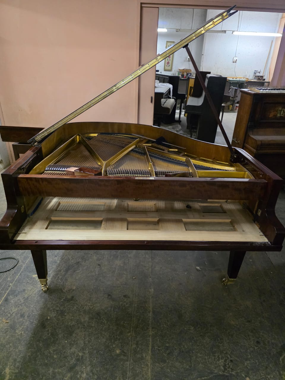 Restored baby grand piano interior with strings and frame