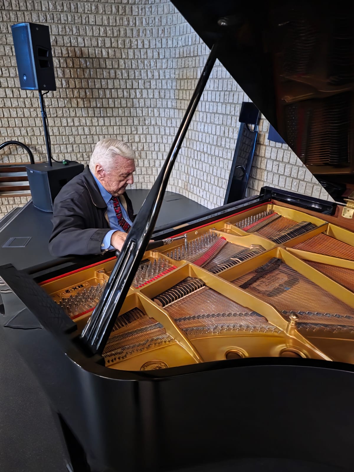 Bennie Dekker tuning a grand piano on location