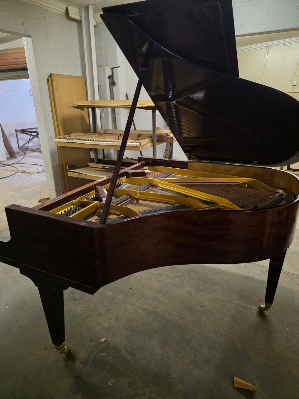 A grand piano with the lid raised, prepared and regulated in our workshop
